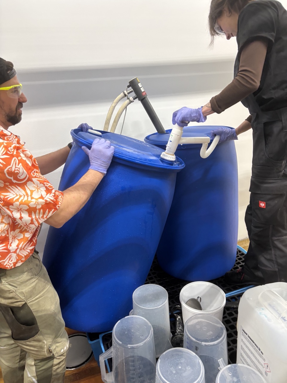 Two-person barrel transfer — one tilts, one pumps